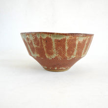 Ceramic bowl with brown and green glaze on a white background