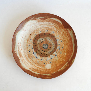 Ceramic plate with concentric circle design on a white background