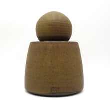 Brown ceramic jar with a spherical top on a white background