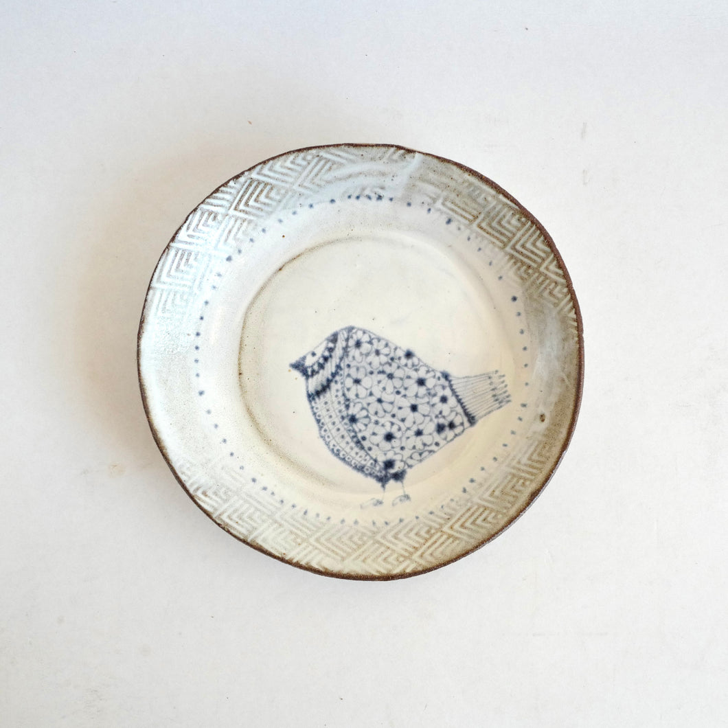 Ceramic plate with decorative bird design on a white background