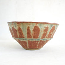 Ceramic bowl with red and green glaze on a white background