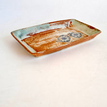 Rectangular ceramic tray with rustic finish and floral bird design on a white background