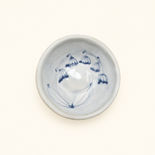 White ceramic bowl with blue decorative elements on a white background