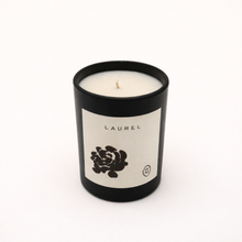 Candle in black holder with “Laurel” label on white background 