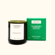 Candle with 'Flamingo Estate' branding next to a green box on a white background