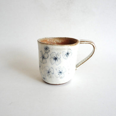 Spako Clay mug.  Blue line flower drawing, white glaze