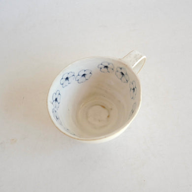 Cappuccino mug with blue flower pattern on beige background