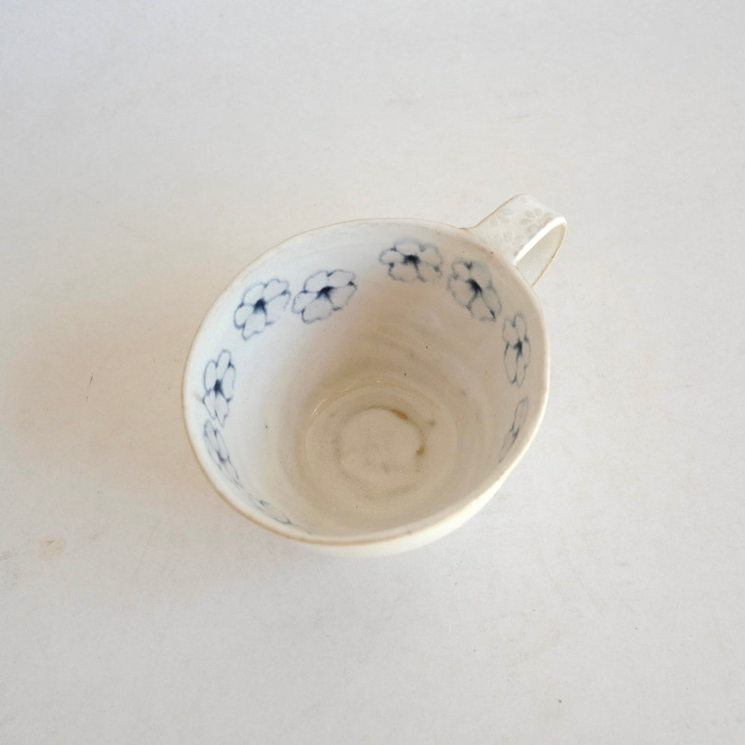 Cappuccino mug with blue flower pattern on beige background