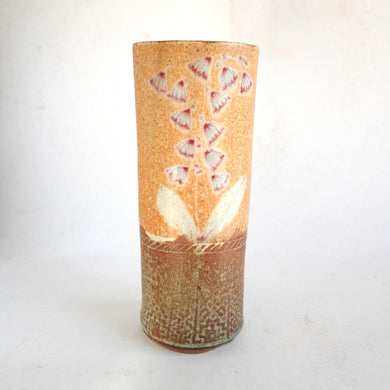 Cylindrical ceramic vase with decorative patterns on a white background