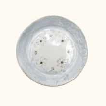 Round ceramic plate with floral patterns on a white background
