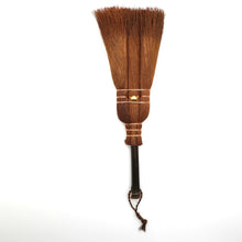Traditional broom with a wooden handle and straw bristles on a white background