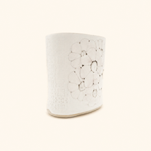 White ceramic vase with a textured surface on a white background