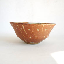 Ceramic bowl with a brown and white speckled pattern on a white background