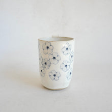 White Mug with blue flower pattern on beige background