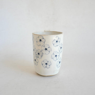 White Mug with blue flower pattern on beige background