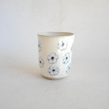 White Tumbler with blue flower pattern on beige background