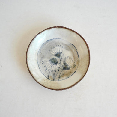 small plate with  blue daisies pattern on white background