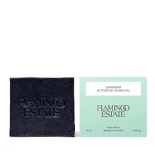 Black soap bar and green packaging with 'Flamingo Estate' branding on a white background