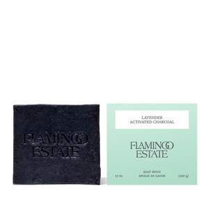 Black soap bar and green packaging with 'Flamingo Estate' branding on a white background
