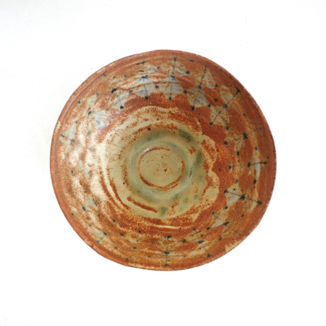 Ceramic bowl with brown and beige glaze on a white background