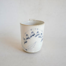 White Mug with blue flower pattern on beige background