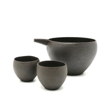 Set of three black ceramic sake set on a white background