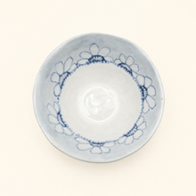 Ceramic bowl with blue floral patterns on a white background