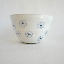 White ceramic bowl with blue floral patterns on a white background