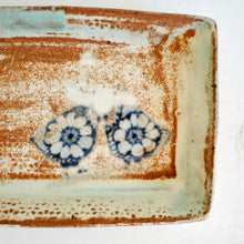 Rectangular ceramic plate with blue bird patterns on a white background