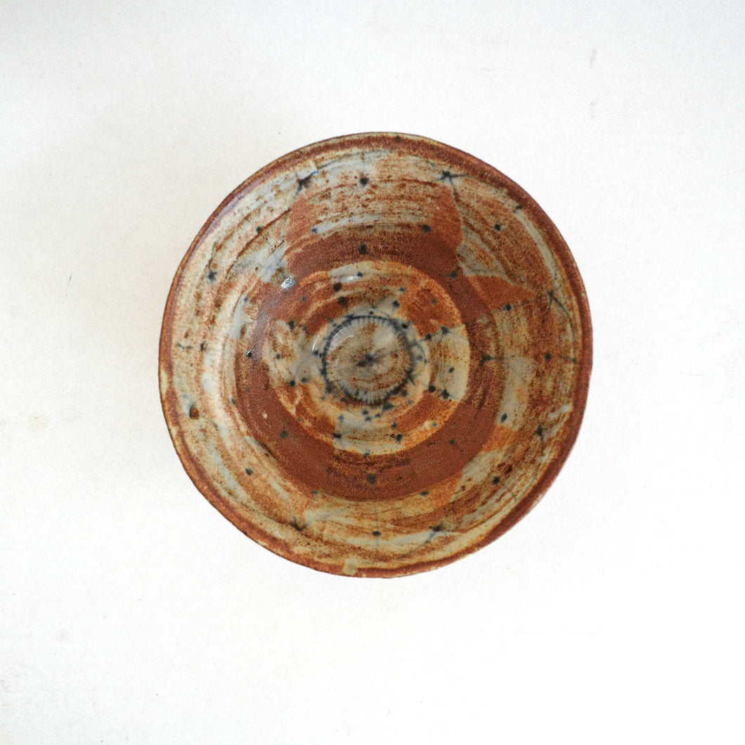 Ceramic bowl with brown and beige swirl pattern on a white background