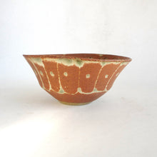 Ceramic bowl with brown and green glaze on a white background