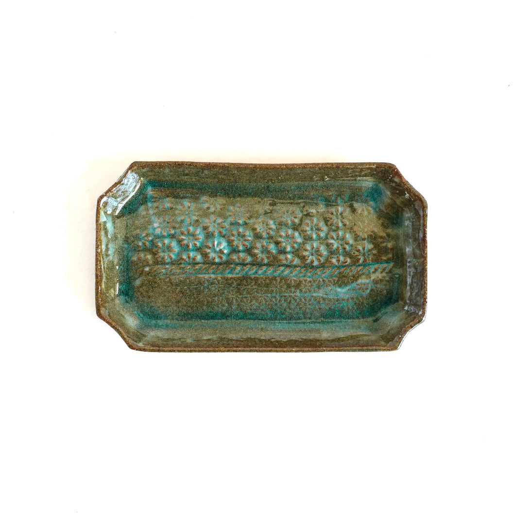 Rectangular ceramic dish with textured surface on a white background