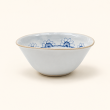 White ceramic bowl with blue floral patterns on a white background