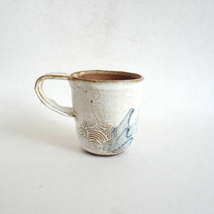Spako Clay mug. Blue line drawing of waves and emboss pattern, white glaze