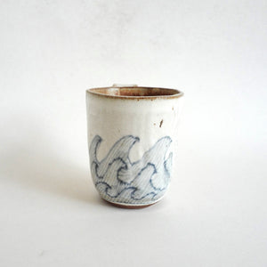 Spako Clay mug. Blue line drawing of waves and emboss pattern, white glaze