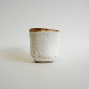 Spako Clay Wide Tumbler single blue flower on white glaze. Foliage texture.