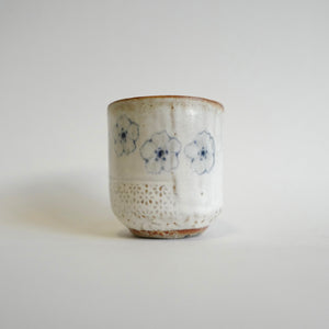 Spako Clay Wide Tumbler multiple blue flower on white glaze. Flower texture.