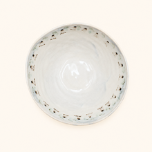 White ceramic bowl with decorative floral pattern on a white background