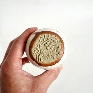 hand holding Spako Clay Wide Tumbler clay texture at base