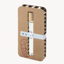 Small glass bottle with wooden cap in a cardboard holder on a white background