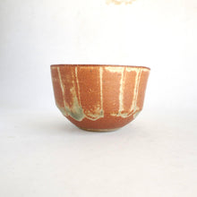 Ceramic bowl with brown and green glaze on a white background