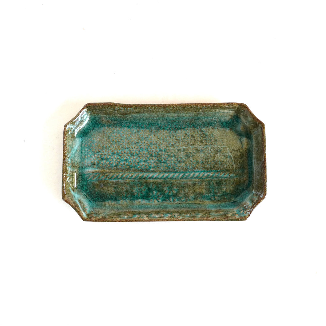 Rectangular ceramic tray with textured blue-green surface on a white background