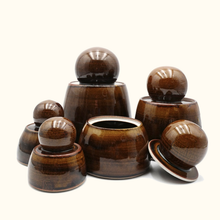 Set of brown ceramic containers with lids on a white background