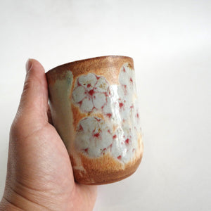 hand holding Spako Clay Wide Tumbler red line drawing, gold spodumene