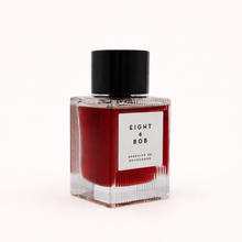Red bottle with black cap labeled 'Eight & Bob' on a white background