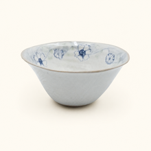 White ceramic bowl with blue floral patterns on a white background