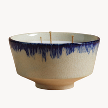 A ceramic bowl-shaped candle with a cream-colored glazed exterior featuring a blue crackle pattern around the rim, three wicks, and a matching cream-colored wick insert inside, set against a plain white background.