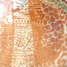 Close-up of a textured ceramic surface with floral patterns