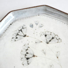 Close-up of a ceramic plate with heart-shaped patterns on a white background