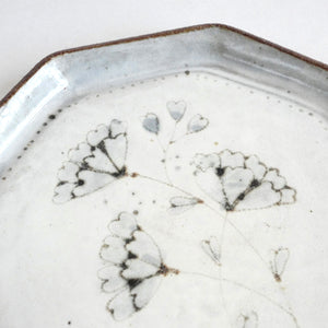 Close-up of a ceramic plate with heart-shaped patterns on a white background